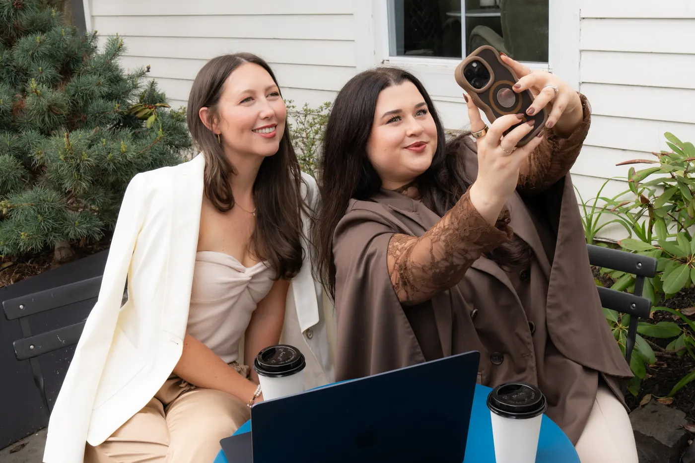 McKenzie taking a selfie with Sallie at a blue cafe table on a patio